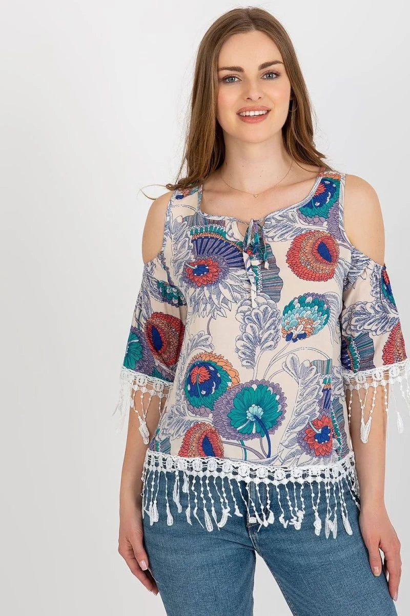 Cream cold-shoulder top with a vibrant floral print, white lace trim on sleeves and hem.