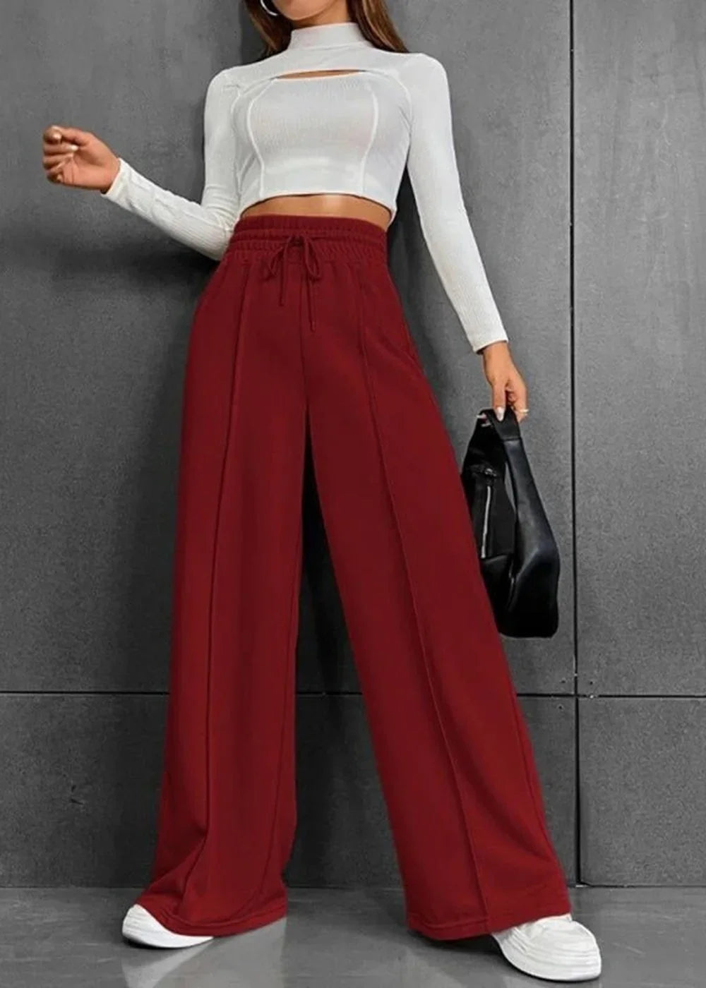 Deep red, wide-leg pants with a drawstring waist and vertical seam detail, worn by a model.