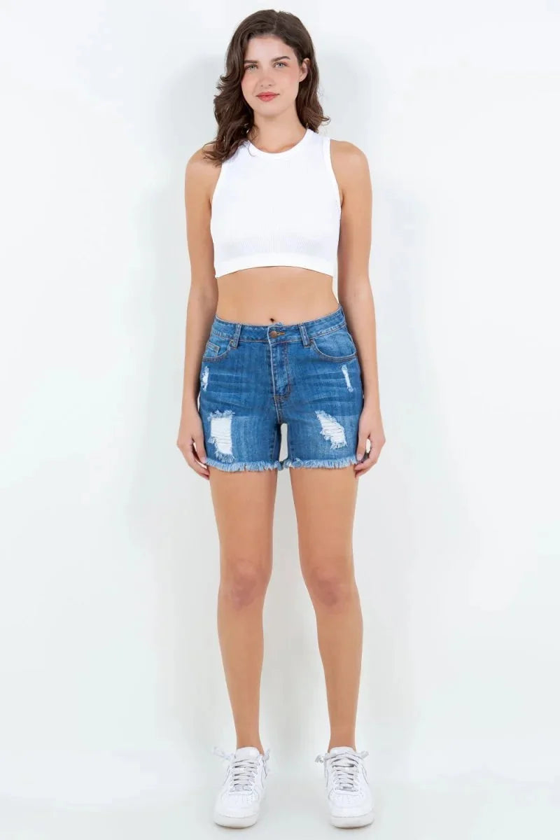 Blue distressed denim shorts with frayed hem, on a model.