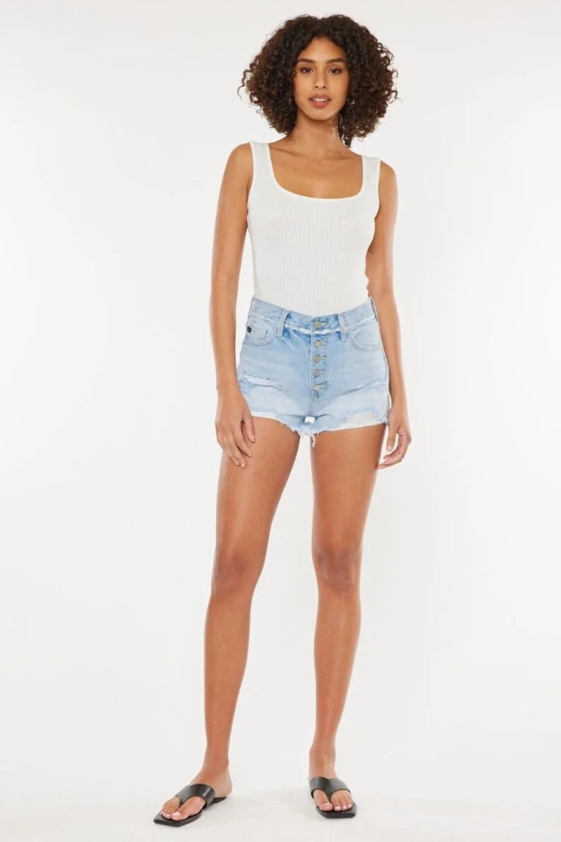Light wash distressed denim shorts with a button fly and frayed hem on a model.
