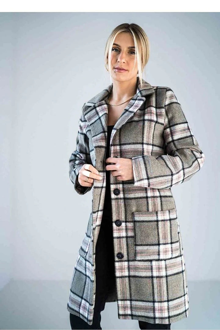 Woman in a grey, black, and pink plaid jacket with button closure and patch pockets.