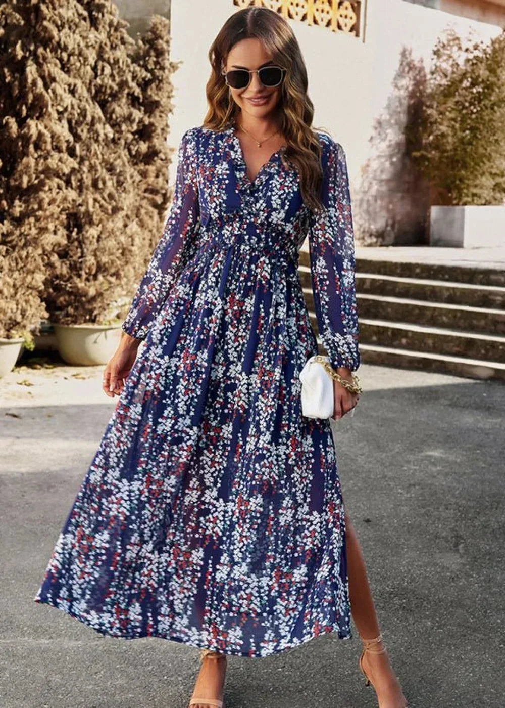 Navy blue floral print maxi dress with v-neck and long sleeves, cinched waist, and thigh-high slit.