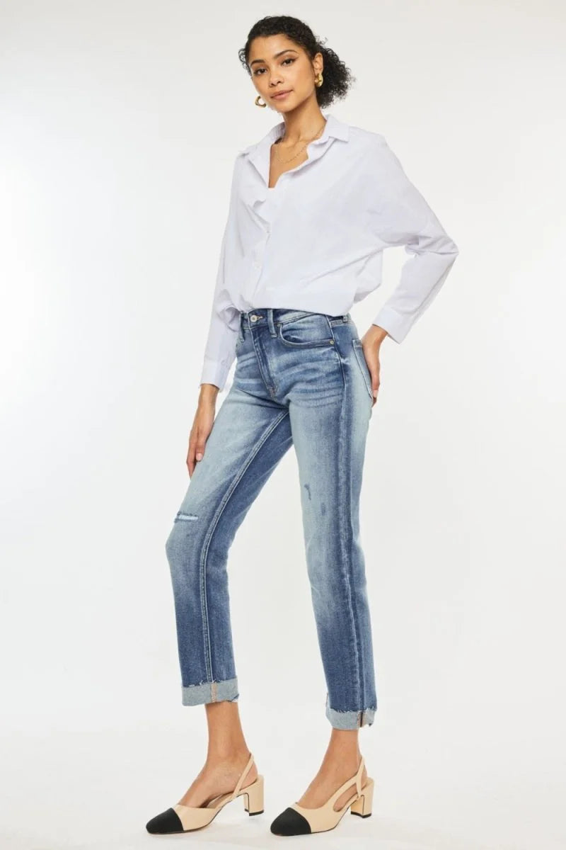 Light blue distressed denim jeans with a cuffed hem and a white button-down shirt on a model.
