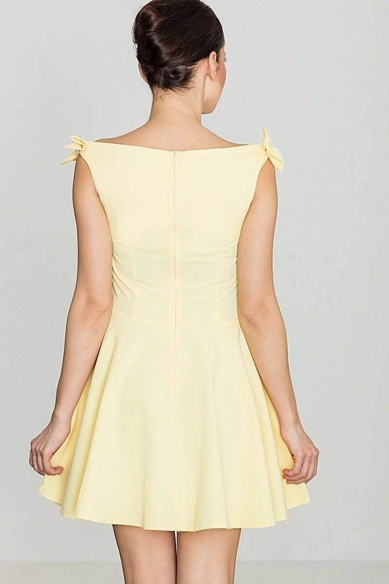 Pale yellow fit-and-flare dress with bow shoulder details, shown from the back.