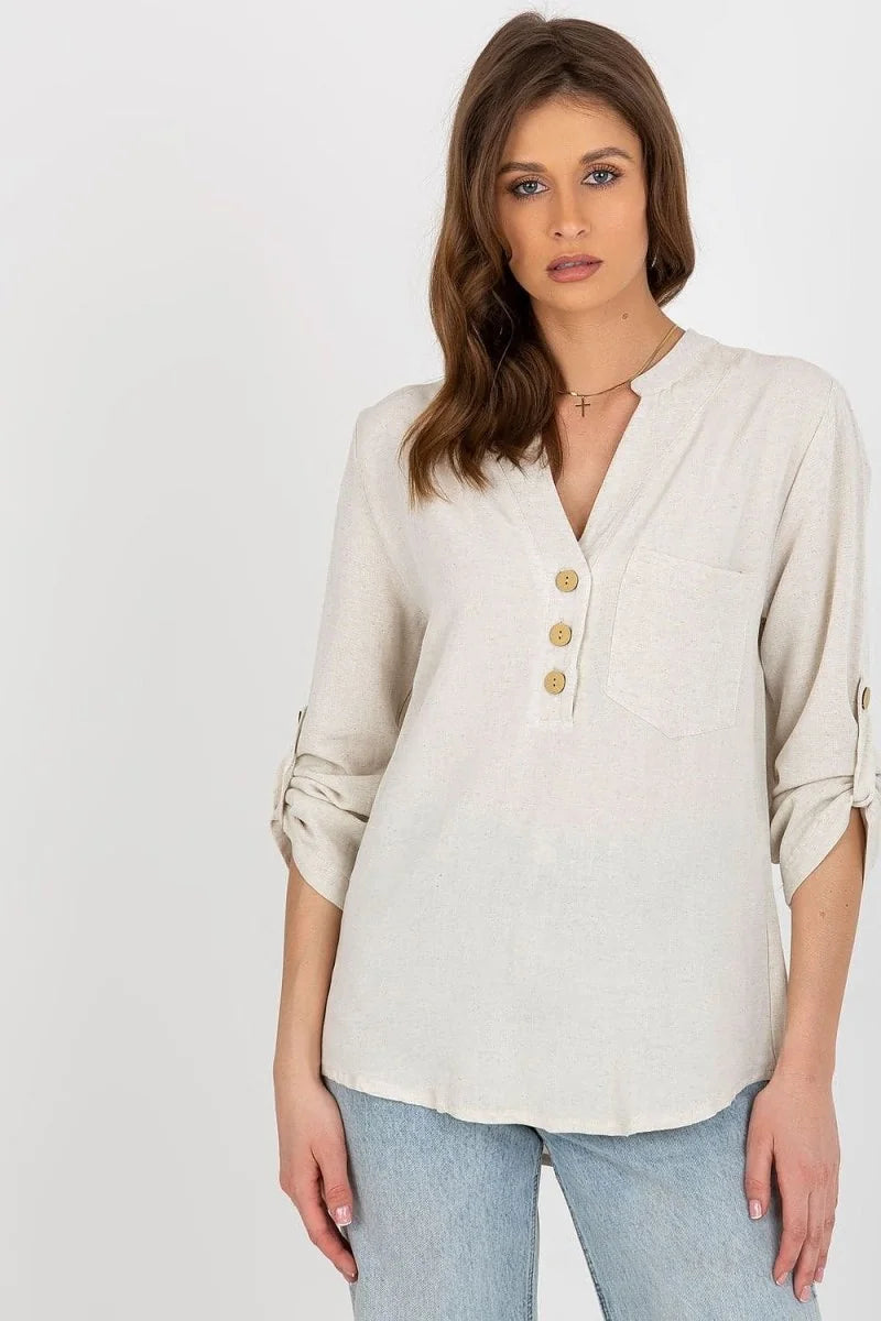 Light beige linen blend tunic top with button-up V-neck, roll-tab sleeves, and chest pocket on model.