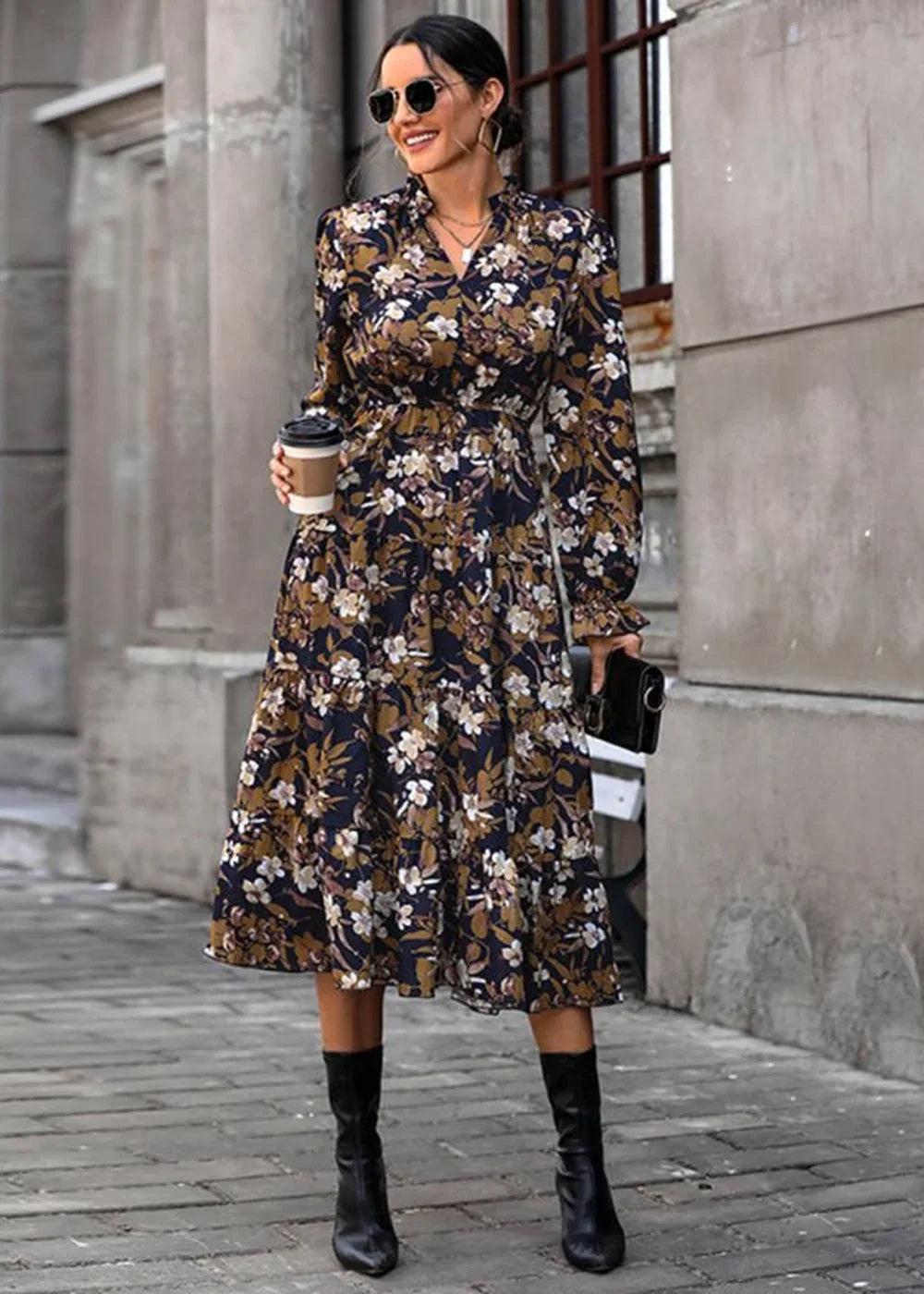 Navy floral print midi dress with long sleeves, cinched waist, and black boots, held by a woman.