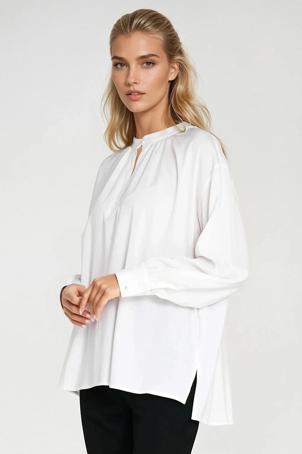 Oversized white viscose shirt with split hem, on model.
