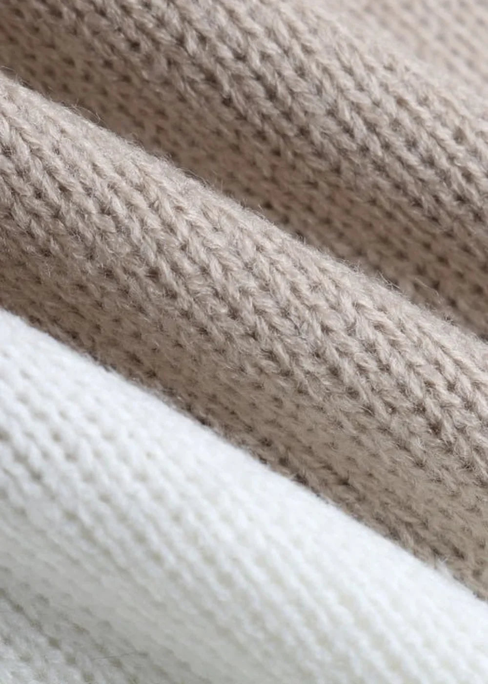 Close-up of soft, textured knit fabric in cream and light brown, showing the cozy weave.