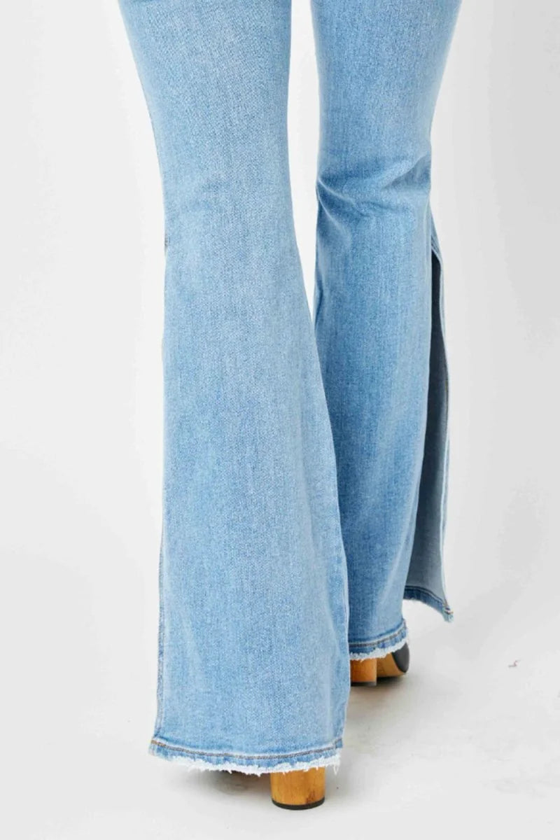 Light wash denim flare jeans with a frayed hem and a side slit.