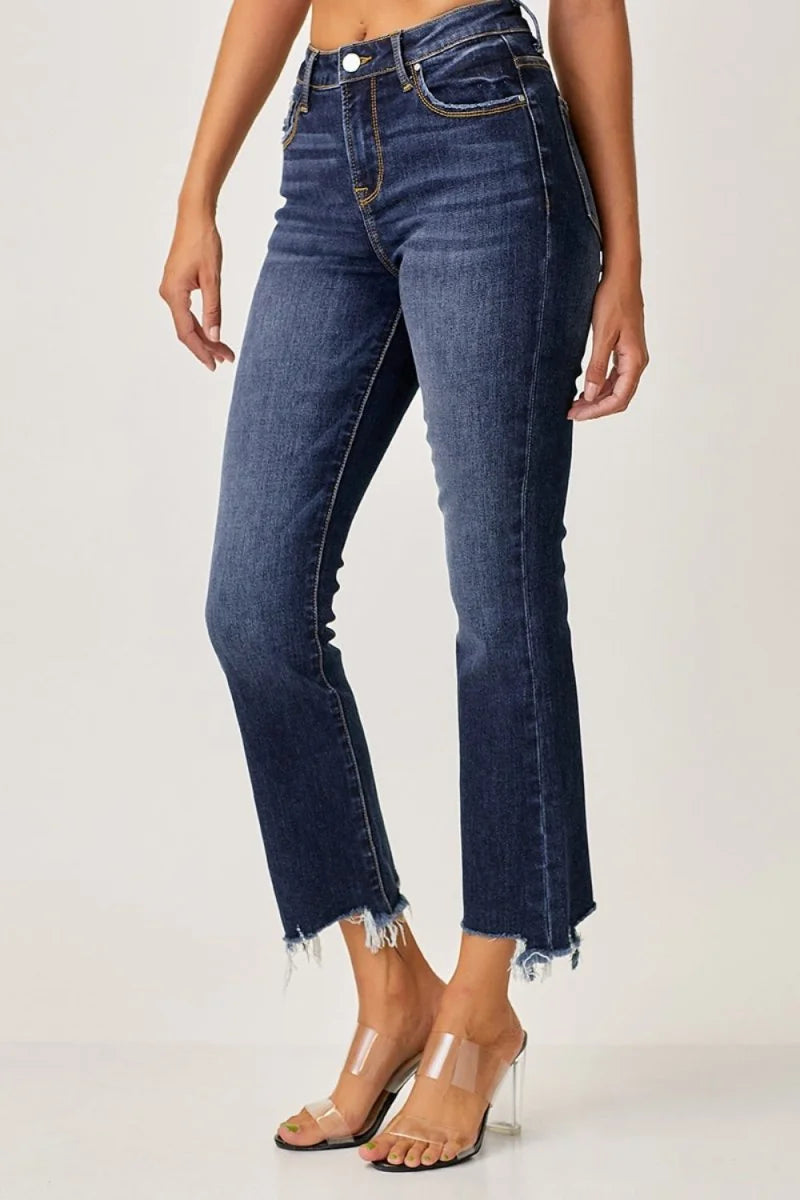 Dark wash denim jeans with frayed hem, slight stretch, on model wearing clear heels.