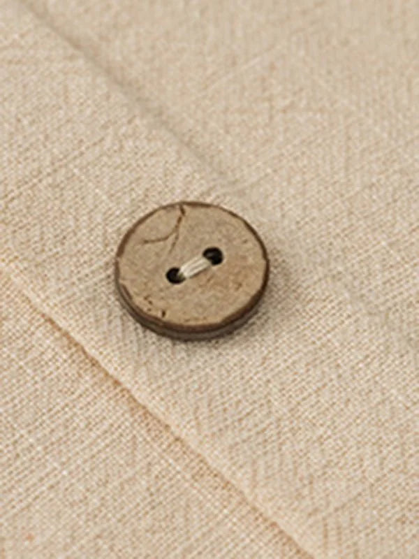 Close-up of a natural fiber fabric with a visible weave and a single coconut shell button closure.