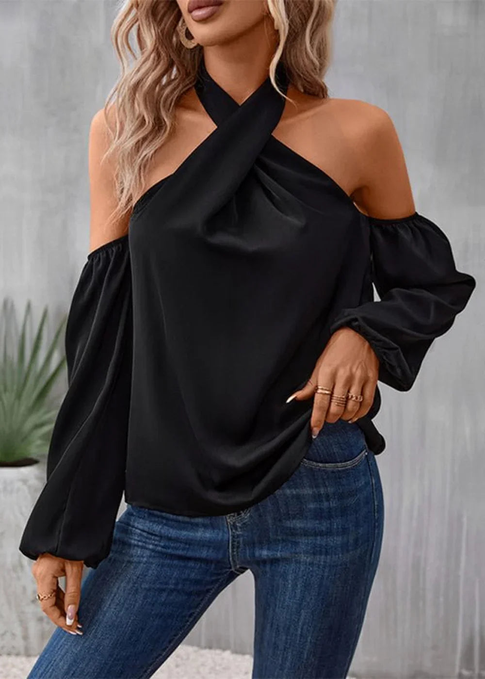 Black off-the-shoulder halter top with draped neckline and long puff sleeves on a model.
