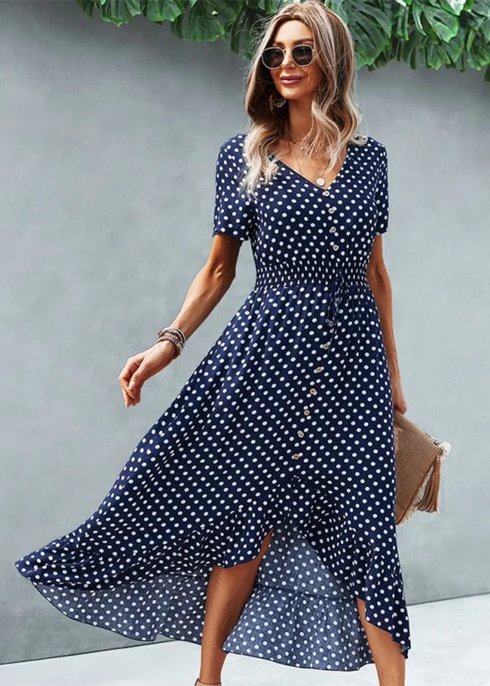 Navy blue polka dot rayon dress with a ruffled hem and button front.