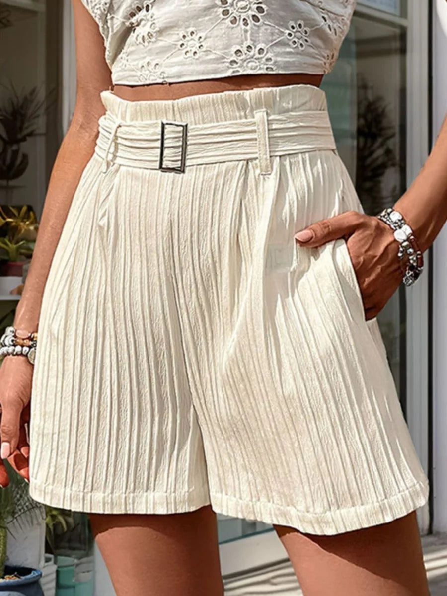Cream textured high-waisted shorts with a belt and pockets, on a model.
