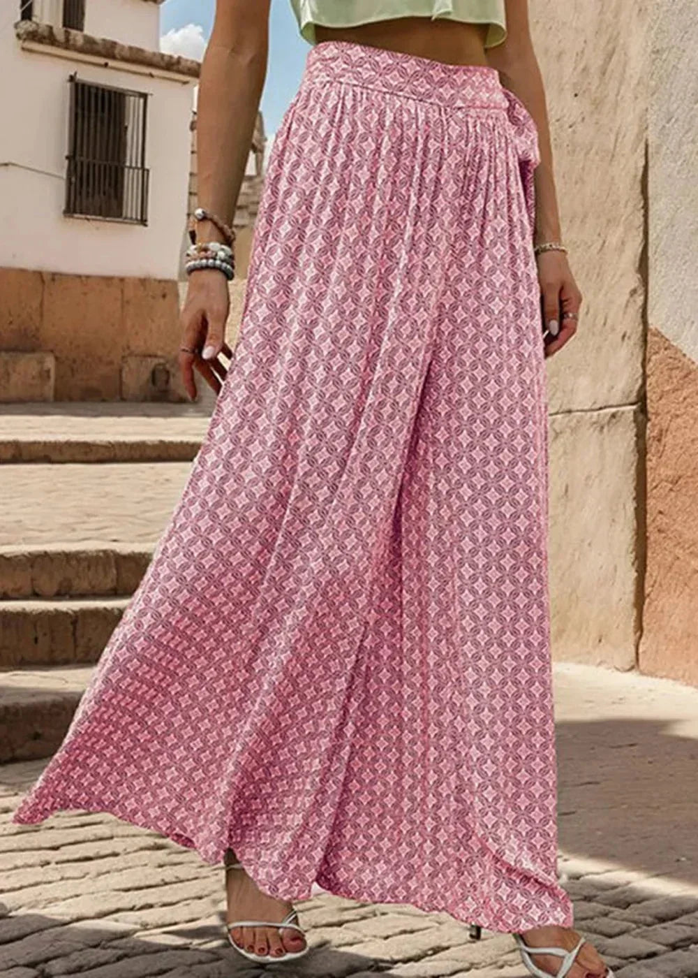 Pink wide-leg pants with a geometric diamond pattern and a tie waist, on a model.