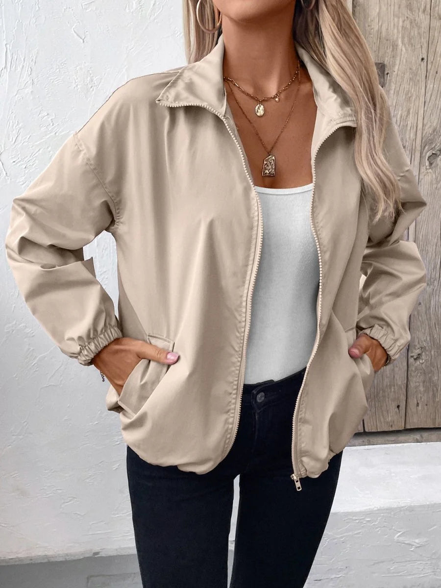 Beige bomber jacket with a zip-up front, elastic cuffs, and pockets on a model.
