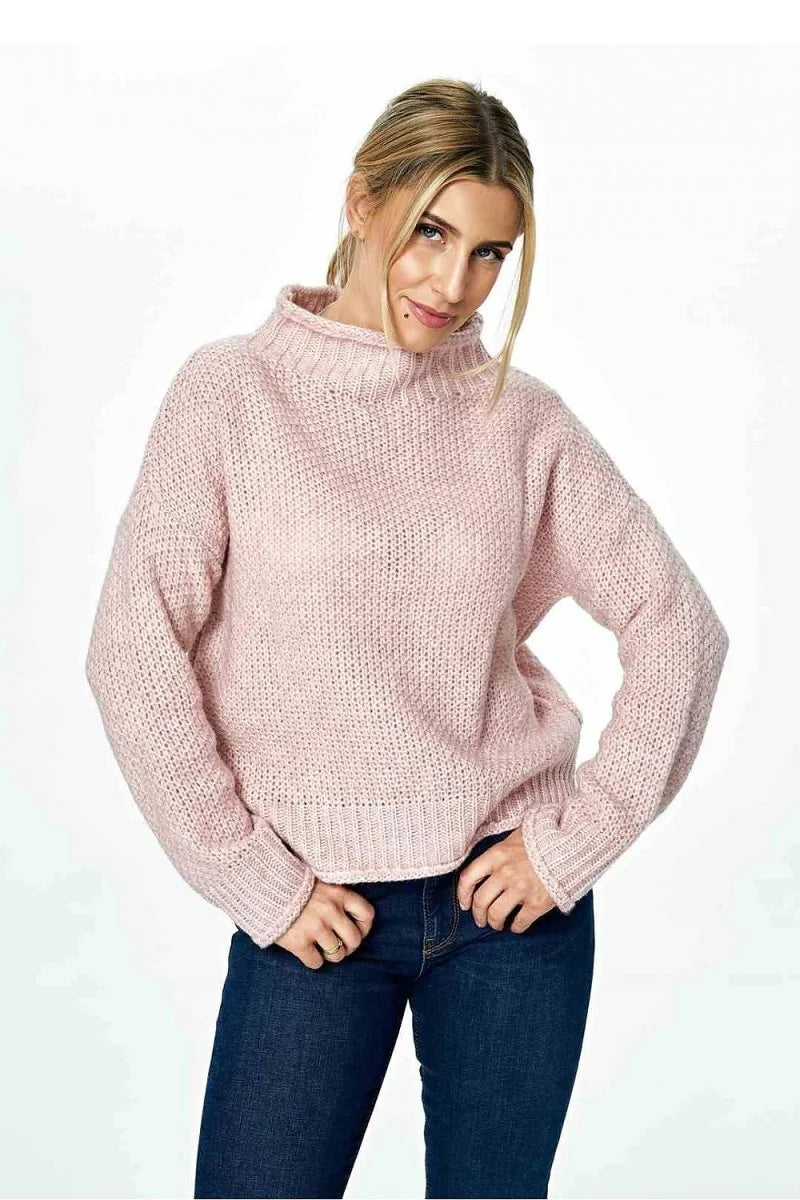 Pink knit turtleneck sweater with a textured stitch and ribbed cuffs.
