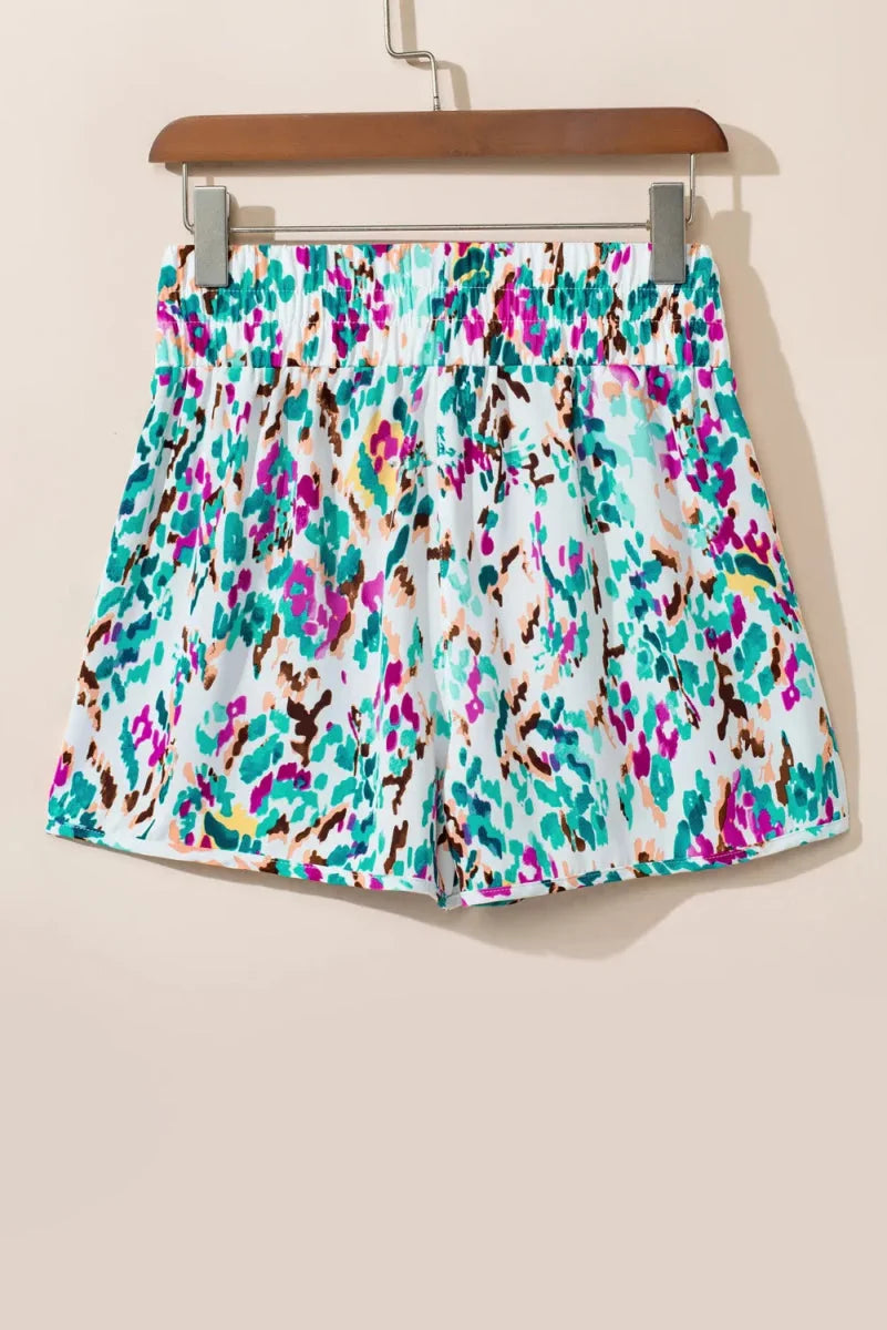 White shorts with a multicolor abstract print and elastic waistband.