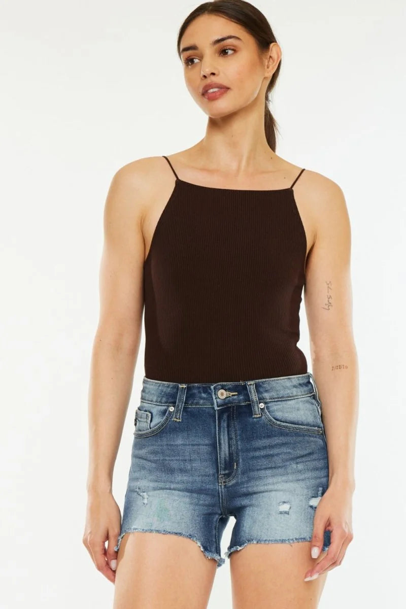 Distressed denim shorts with frayed hem and a high-rise fit on a model.