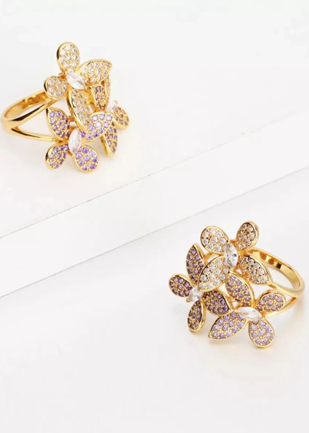 Gold ring with purple and clear rhinestones arranged in a floral cluster design.