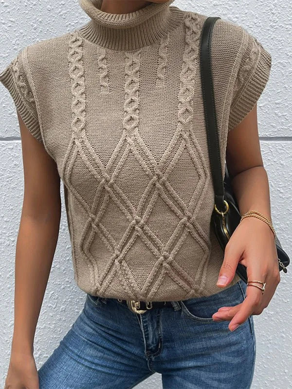 Tan sleeveless knit turtleneck sweater with cable knit diamond pattern on model.