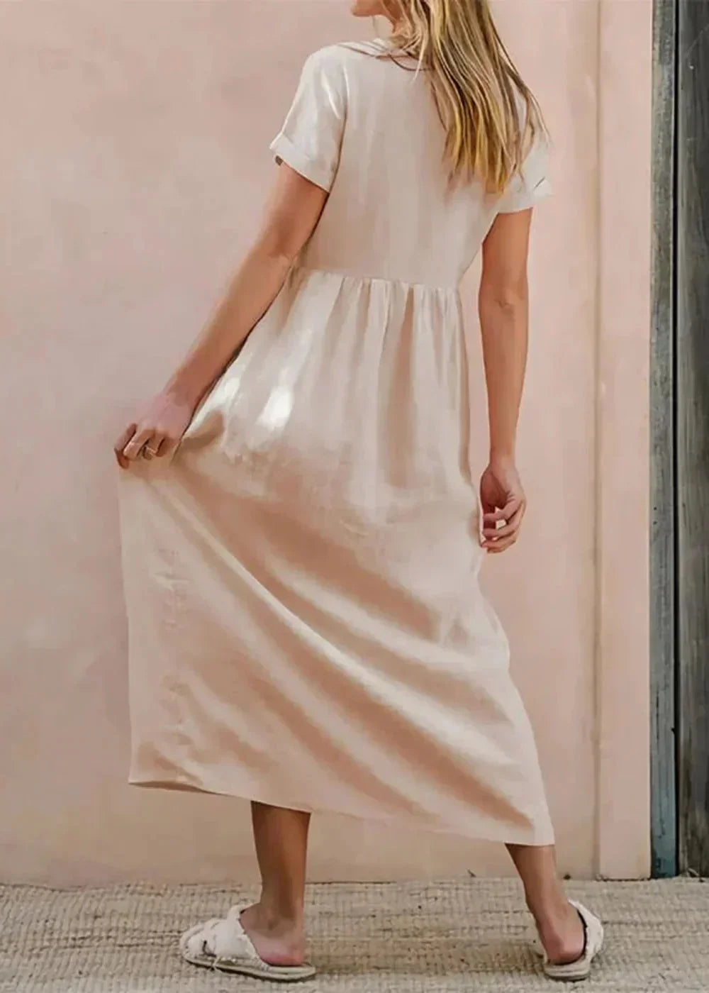 Cream cotton midi dress with short sleeves and cinched waist, shown from the back on a model.
