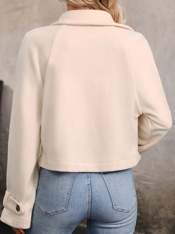 Cream cropped jacket with buttoned cuff detail, shown from the back over light blue jeans.