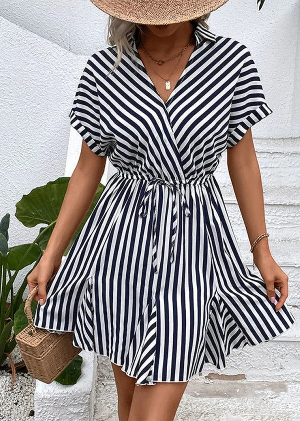 Navy and white striped wrap dress with a tie waist and a straw hat.