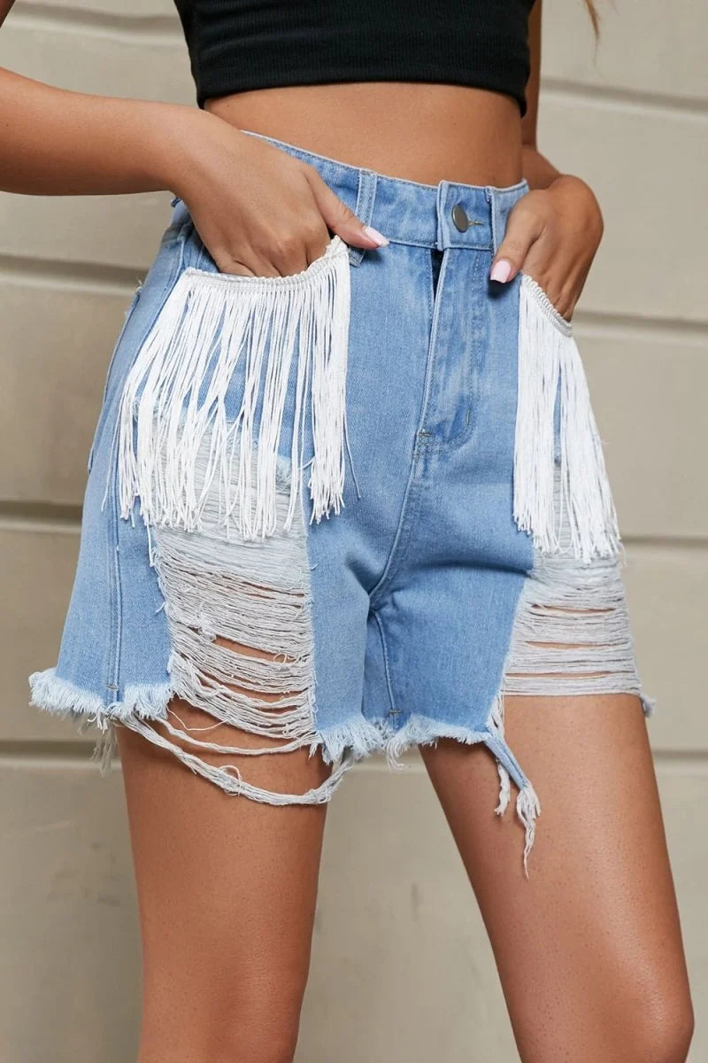Distressed light wash denim shorts with white fringe trim on pockets and frayed hem.
