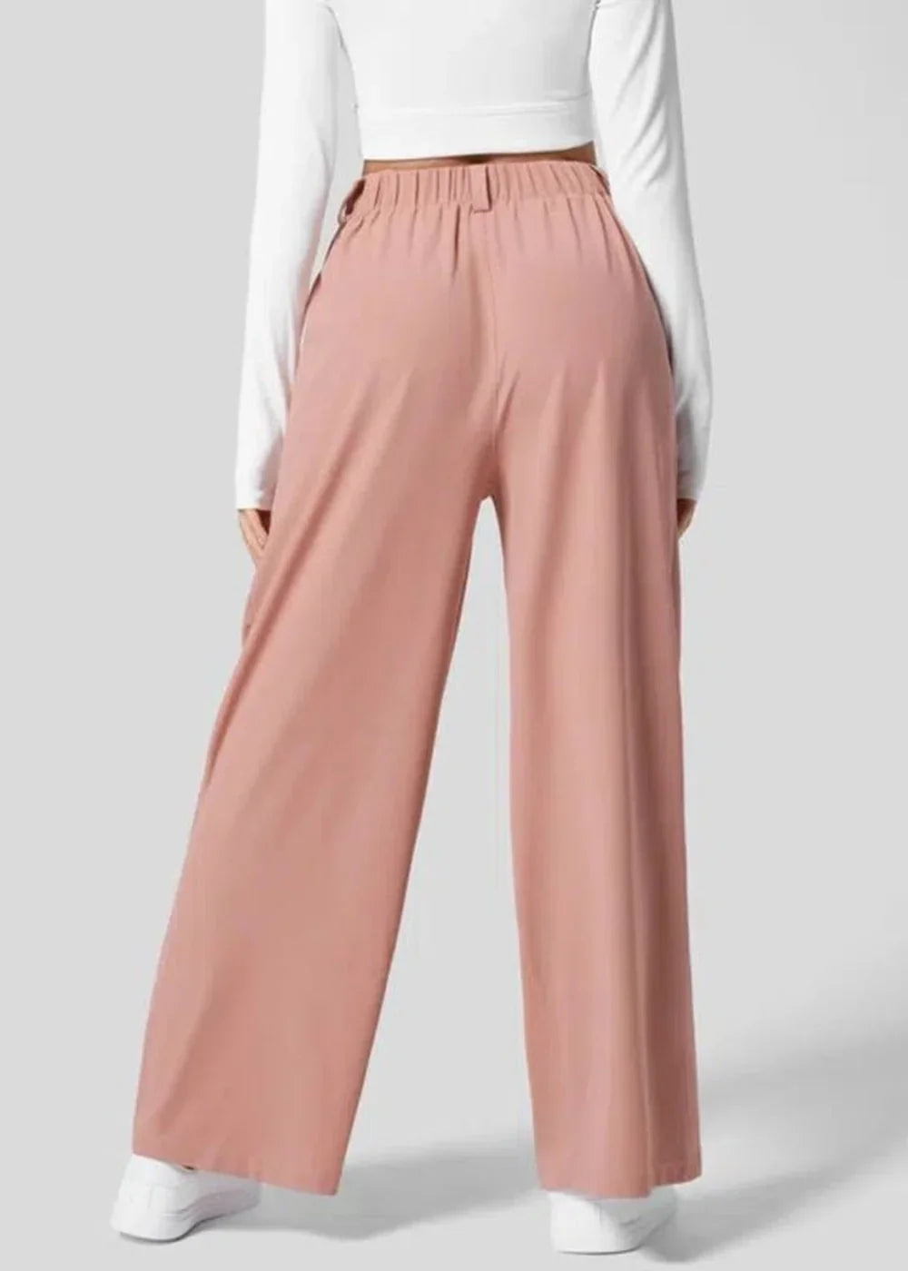 Back view of dusty rose wide-leg pants with elastic waistband and white sneakers.