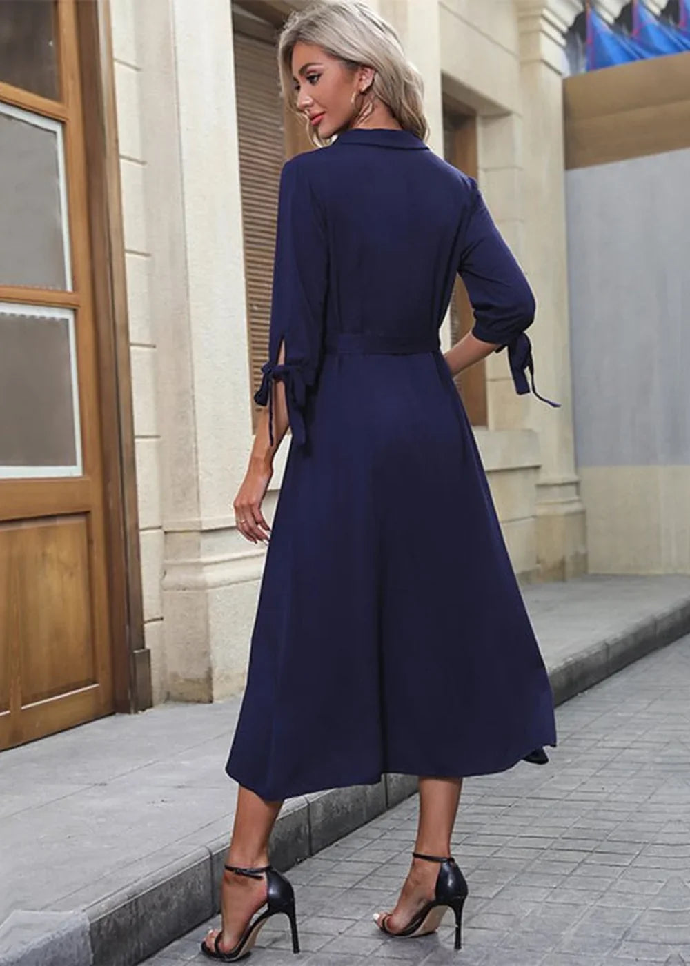 Navy blue rayon midi dress with tie-sleeve detail and belted waist, worn with black heels.