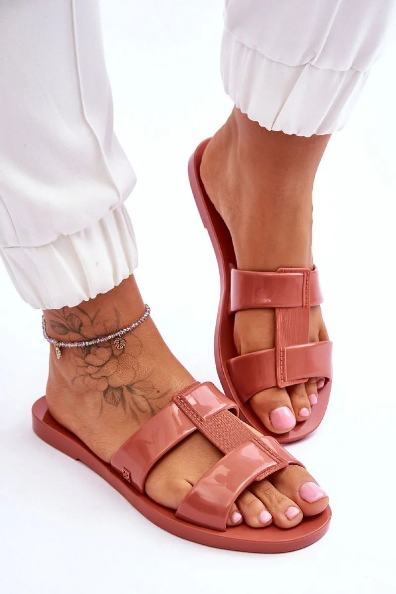Rose plastic flip-flops with a textured strap and glossy finish.