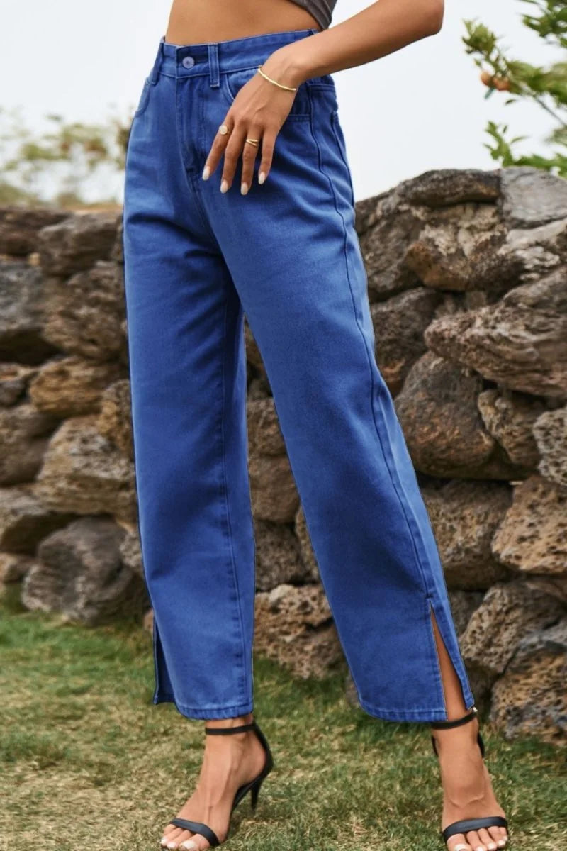 Navy blue wide-leg jeans with side slits and a high-waisted fit, worn with black heels.