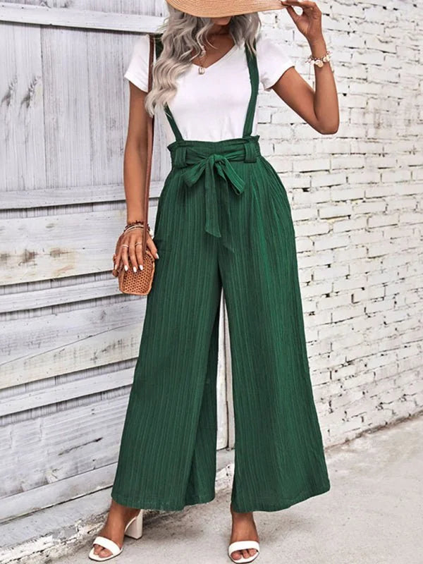 Dark green wide-leg suspender pants with a tie waist and ribbed texture.