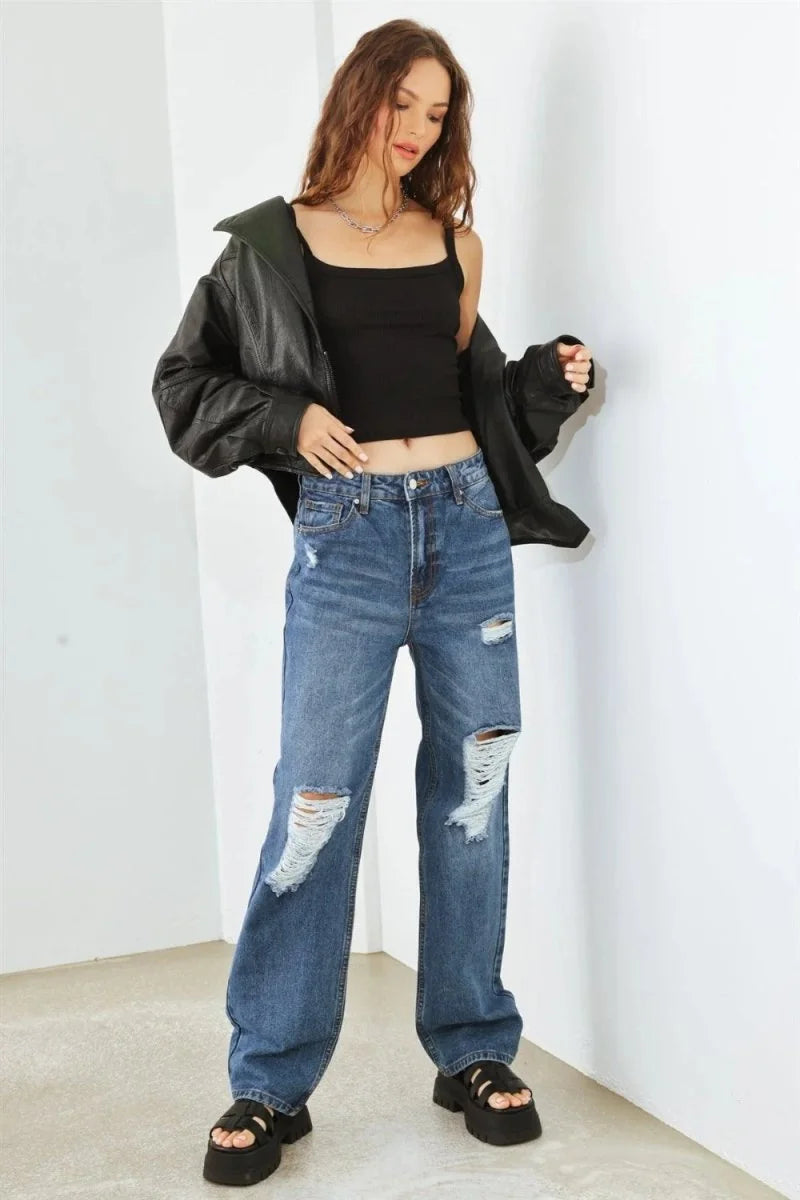 Distressed medium wash denim jeans with a relaxed fit, shown on a model.