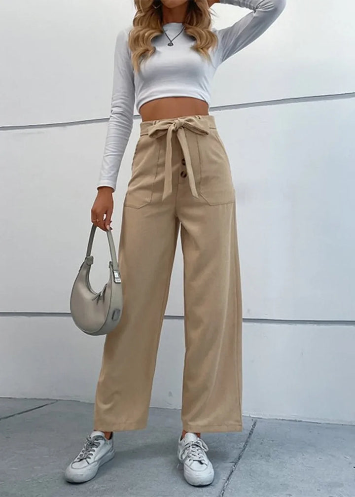 Khaki wide-leg pants with a tie waist, button closure, and pocket details on a model.