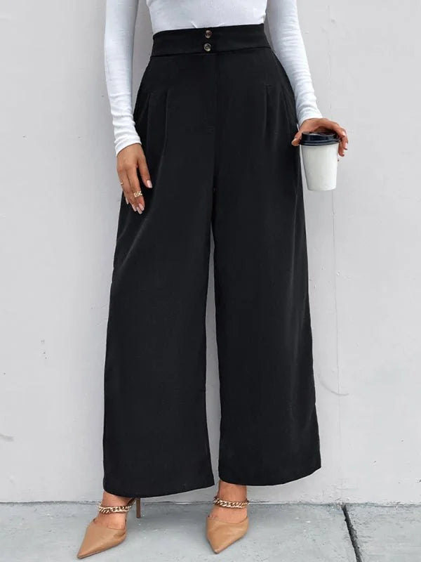Black wide-leg trousers with high waist and two button closure, worn with tan pointed-toe heels.