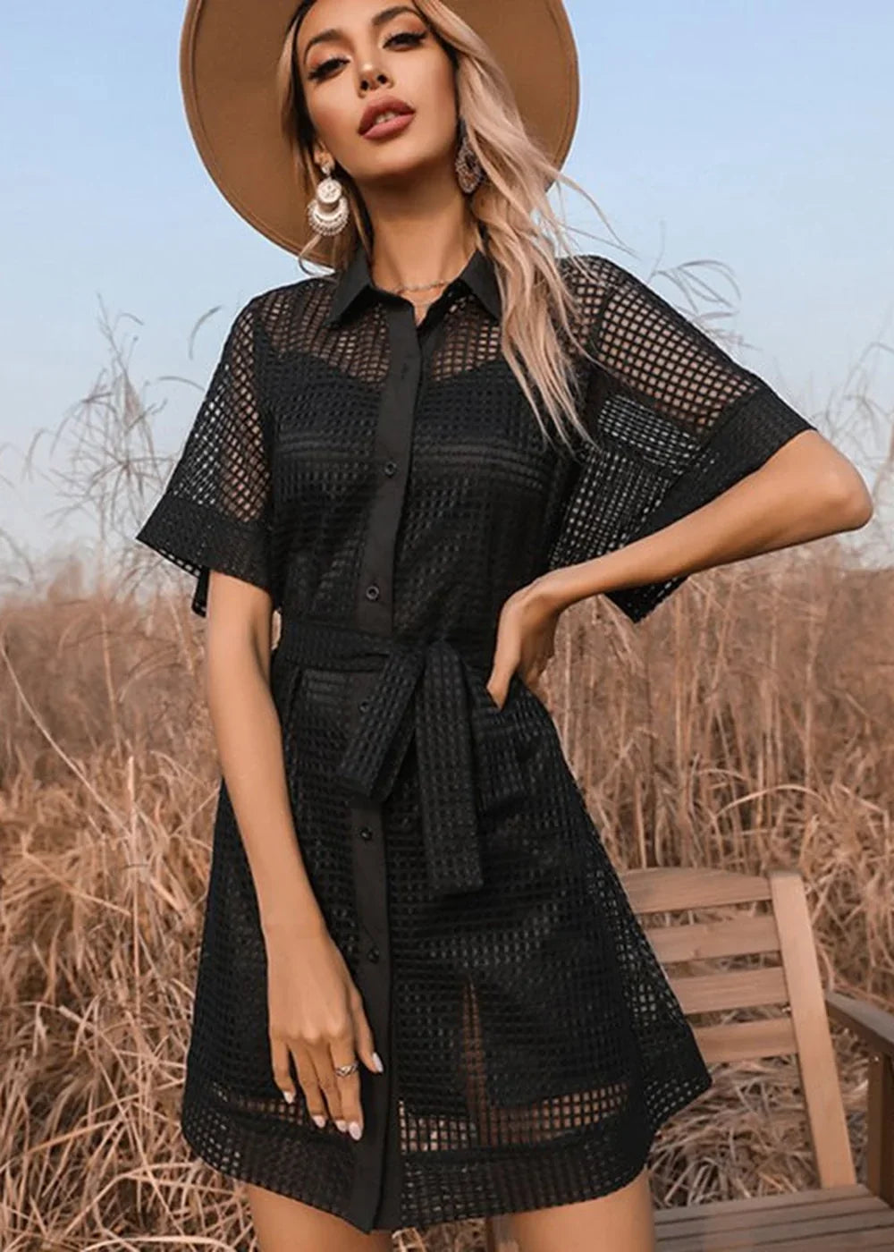 Black sheer mesh shirt dress with tie waist and button front, on model.