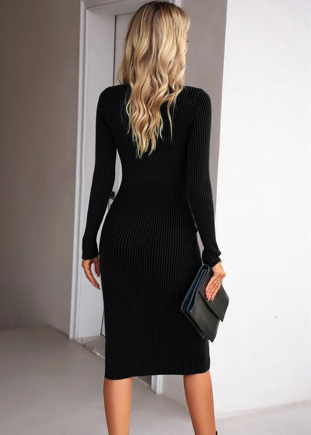 Black ribbed knit midi sweater dress with long sleeves, worn by a model holding a black clutch.
