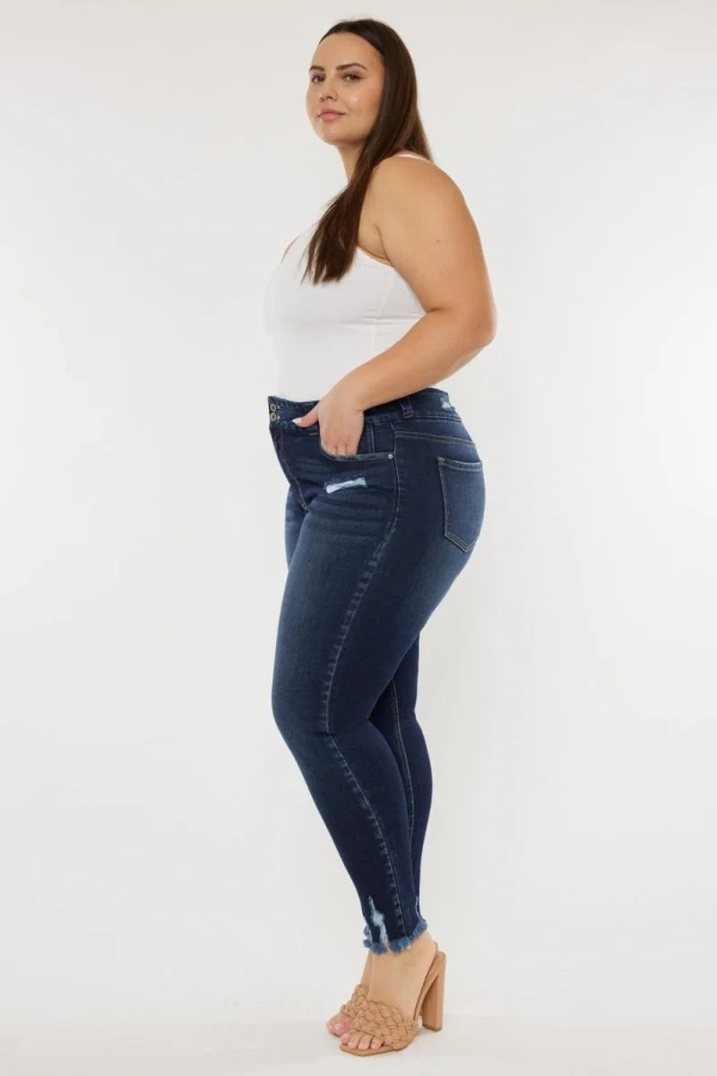 Dark wash skinny jeans with distressed details and frayed hem, on a model.