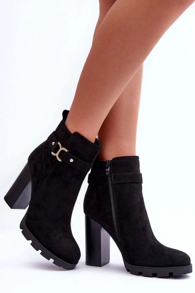 Black suede ankle boots with chunky heels, gold buckle detail, and side zippers.