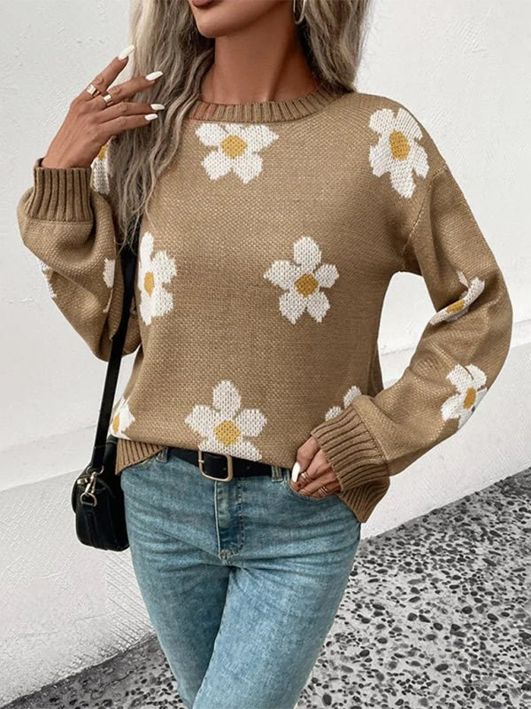 Tan knit sweater with white and yellow floral pattern, long sleeves, and ribbed cuffs on model.