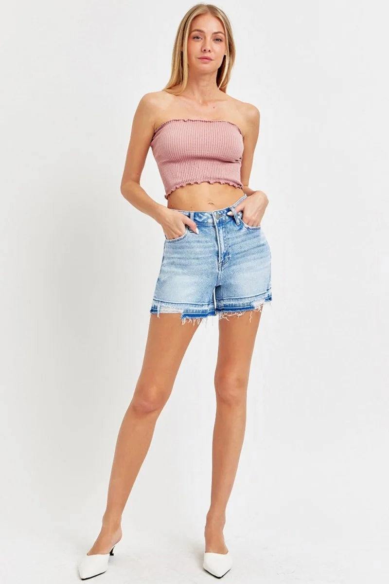 Light blue high-rise denim shorts with frayed hem detail, on model.