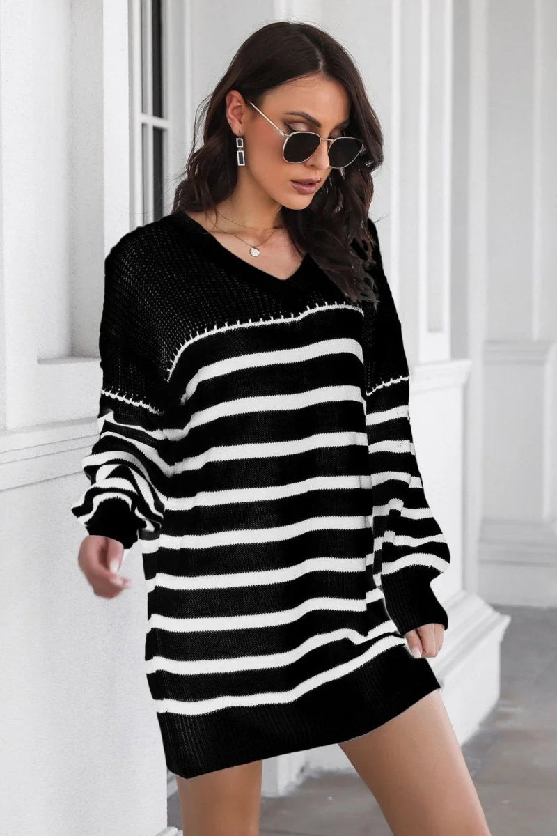 Black and white striped knit sweater dress with a v-neck and long sleeves.