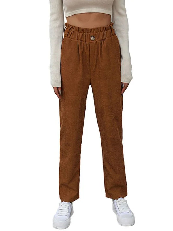 Brown corduroy pants with paperbag waist and button detail on model