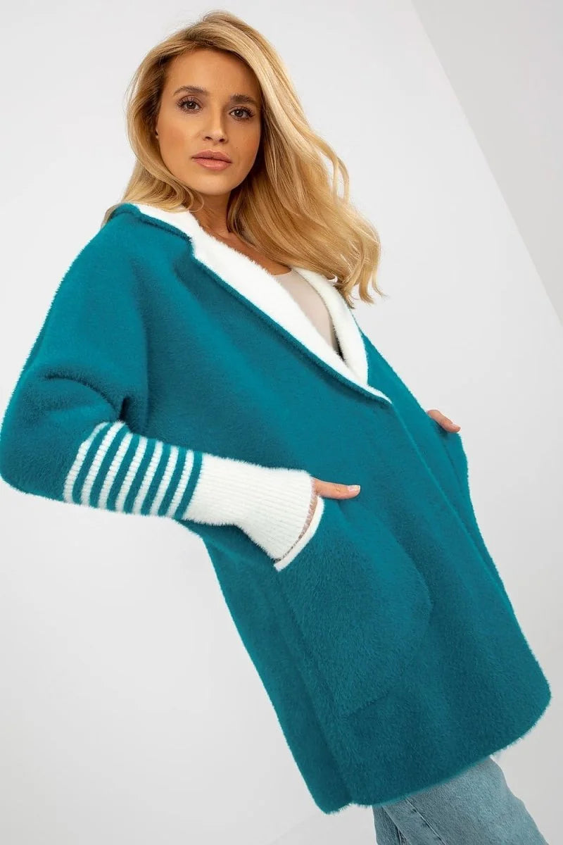 Teal fluffy cardigan with white trim and striped cuffs on model.