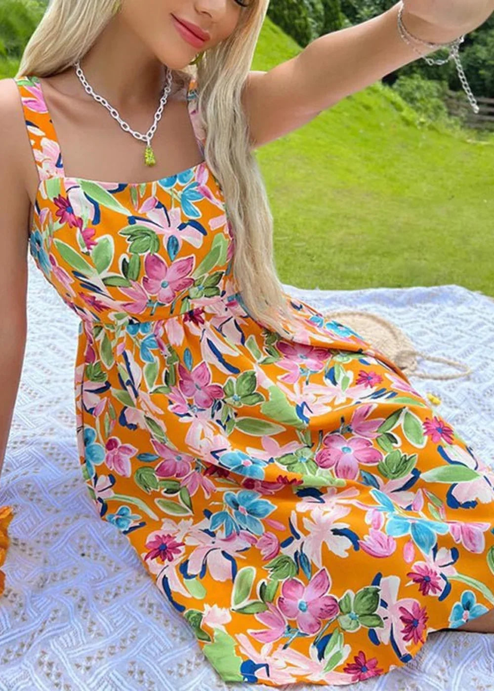 Orange day dress with a vibrant floral print, featuring pink, blue, and green flowers.
