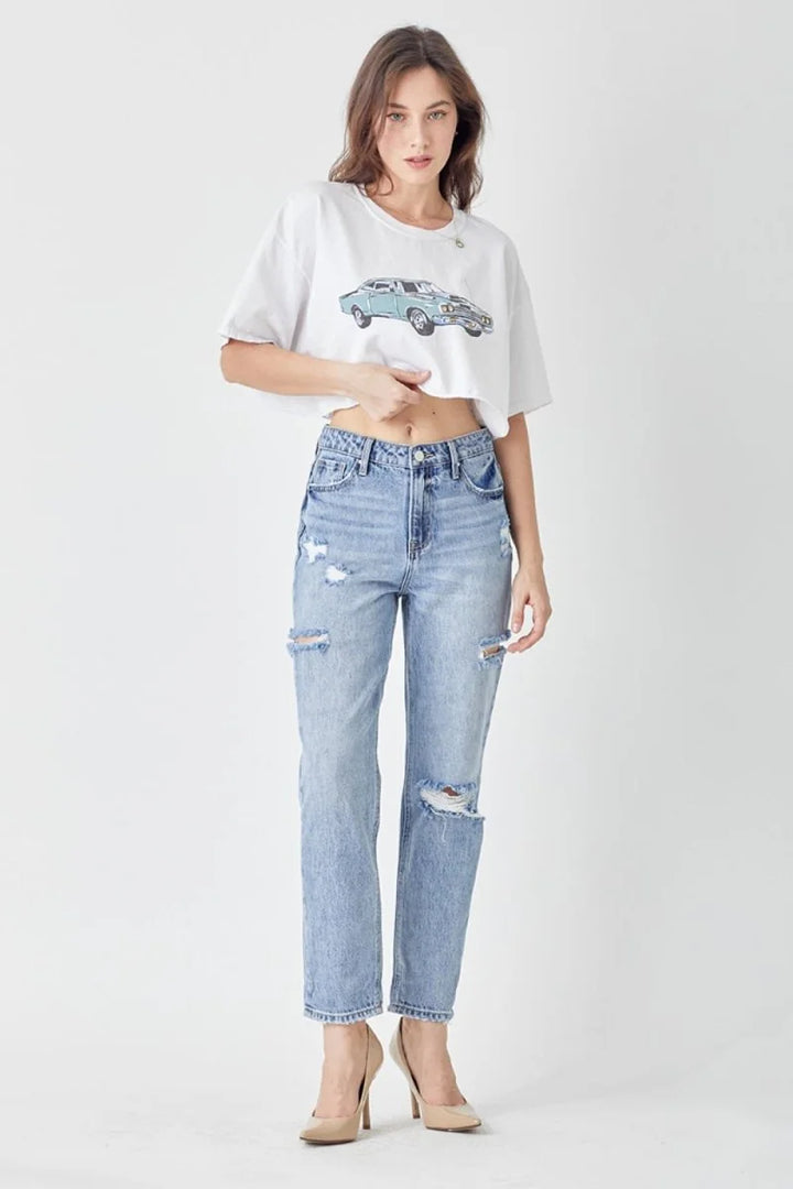 Distressed light wash denim jeans with ripped knees, slim fit, on model.