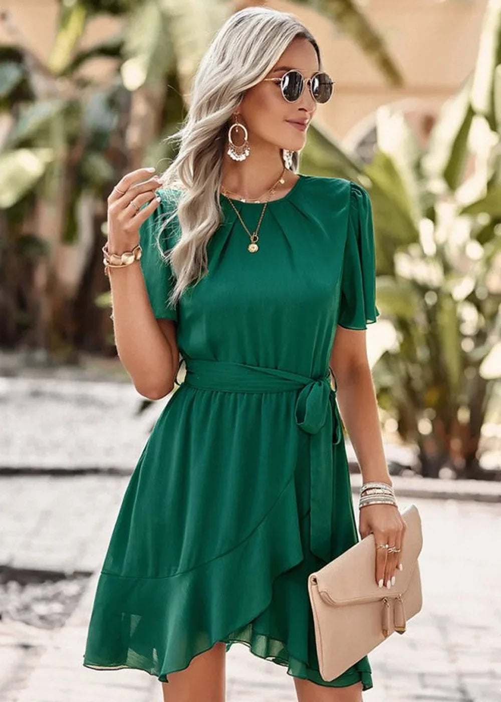 Emerald green ruffled wrap dress with a tie waist and short puff sleeves, worn by a model.