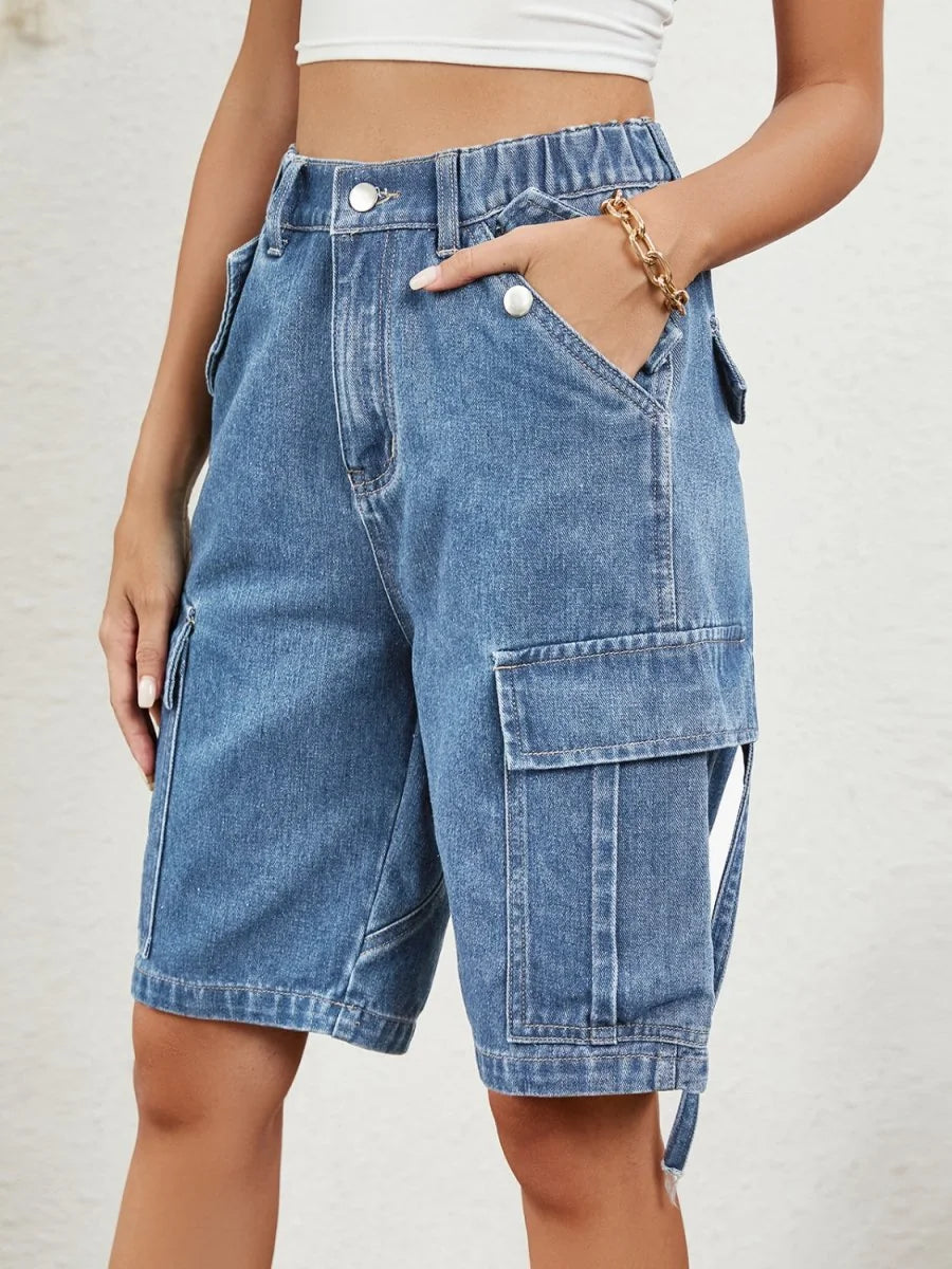 Light wash denim cargo shorts with prominent pockets and gold chain bracelet on model.